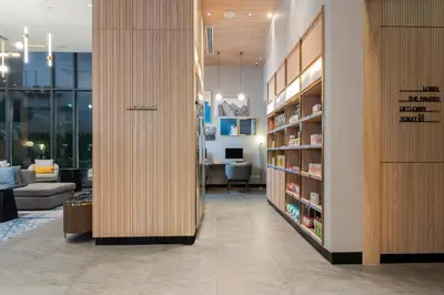 a room with a library with a couch and a table at Staybridge Suites Bangkok Thonglor by IHG in Bangkok