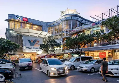 a parking lot with cars parked in front of a building at Staybridge Suites Bangkok Thonglor by IHG in Bangkok
