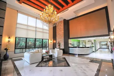 a large lobby with white furniture and a chandelier at 42Grand Residence in Bangkok