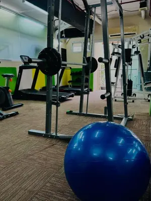 a gym with a large blue ball in front of machines at 42Grand Residence in Bangkok