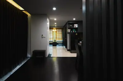a dark room with a hallway with a kitchen at 42Grand Residence in Bangkok