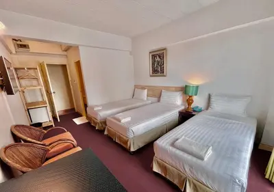 a hotel room with two beds and a couch at MANGO Lagoon Place in Bangkok