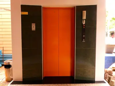 an orange and black elevator in a building at MANGO Lagoon Place in Bangkok