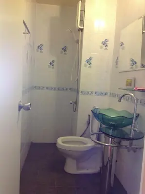 a bathroom with a toilet and a shower with a sink at Baan Khun Rak in Bangkok