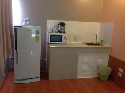 a small kitchen with a refrigerator and a microwave at Baan Khun Rak in Bangkok