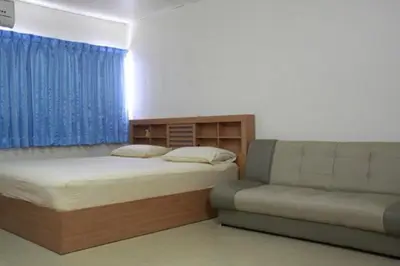 a bedroom with two beds and a couch in it at Baan Khun Rak in Bangkok