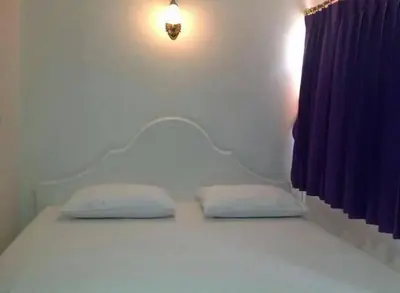 a bed with two pillows on it in a room at Baan Khun Rak in Bangkok