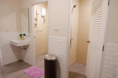 a white bathroom with a sink and a shower at Lisa'House in Bangkok