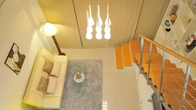 a room with a staircase with chairs and a light at Duplex 21 Apartment in Bangkok