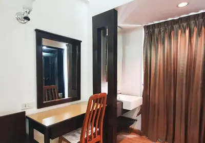 a bathroom with a sink and a desk and mirror at Next Bird Suite SHA in Nonthaburi