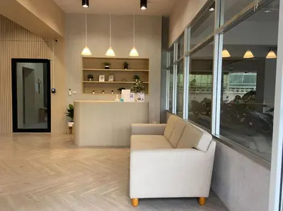a lobby with a white couch and a counter at Next Bird Suite SHA in Nonthaburi