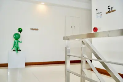 a green figurine on a wall in a room at Pentafield City Residence in Amphoe Phra Khanong
