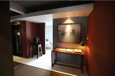 a room with a table and a painting on the wall at Loogchoob Homestay in Bangkok