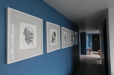a row of framed photographs on a blue wall at Loogchoob Homestay in Bangkok