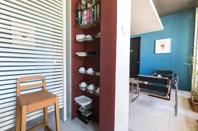 a room with a chair and a shelf with dishes at Loogchoob Homestay in Bangkok