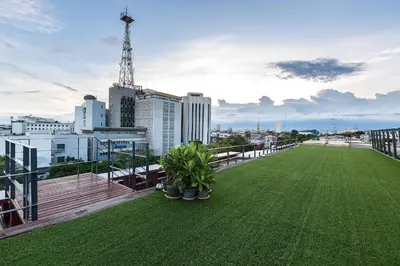 a balcony with a green lawn on the roof of a building at Loogchoob Homestay in Bangkok