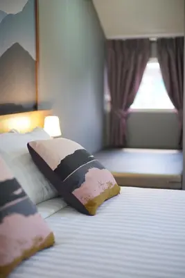 a hotel room with a bed with a pillow on it at The Qube fifty Hotel in Bangkok