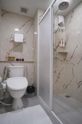 a bathroom with a toilet and a shower at The Qube fifty Hotel in Bangkok