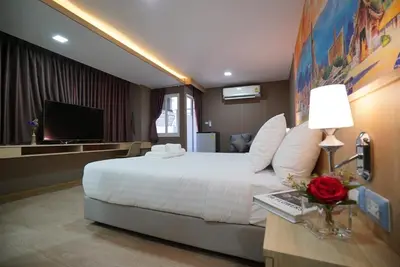 a hotel room with a large bed and a television at The Qube fifty Hotel in Bangkok