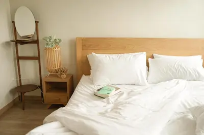 a bed with white sheets and a book on it at YAKTHAI POSHTEL in Bangkok
