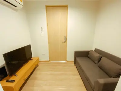a living room with a couch and a television at YAKTHAI POSHTEL in Bangkok