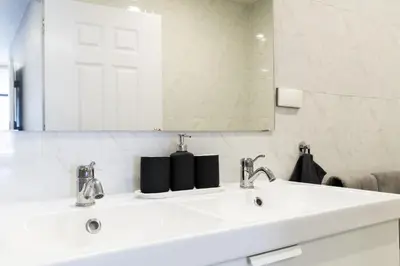 a white bathroom with a sink and a mirror at Cozy Studio 1 in Sathorn, BTS Saint Louis in Bangkok