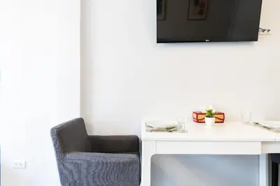 a desk with a chair and a tv on a wall at Cozy Studio 1 in Sathorn, BTS Saint Louis in Bangkok