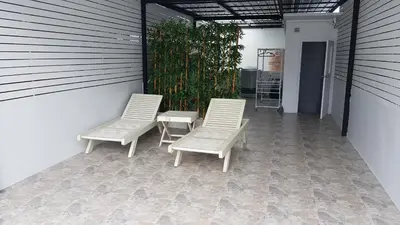 two white chairs and a table on a patio at Cozy Studio 1 in Sathorn, BTS Saint Louis in Bangkok