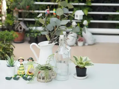 a table topped with vases and potted plants at Makkasan Happy Home in Bangkok