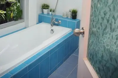 a bathroom with a blue and white bath tub at Makkasan Happy Home in Bangkok