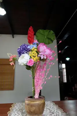 a vase filled with colorful flowers on a table at Yesterday Sathon in Bangkok