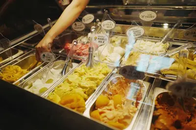 a person is preparing food in a buffet at GHEE GELATO HOUSE in Bangkok