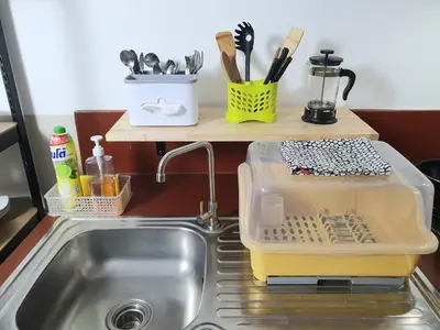 a kitchen sink with a dish drying rack next to it at Villa Thaï Sukhumvit Asok Nana in Bangkok