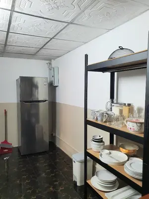 a kitchen with a refrigerator and shelves of dishes at Villa Thaï Sukhumvit Asok Nana in Bangkok