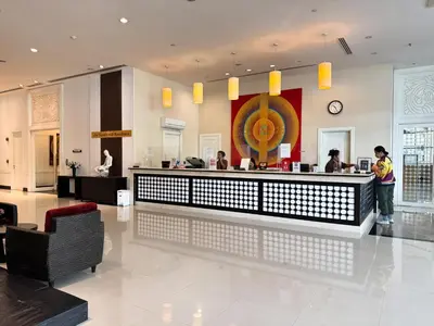 a lobby of a restaurant with people standing at a counter at The Narathiwas Hotel & Residence Sathorn Bangkok in Bangkok