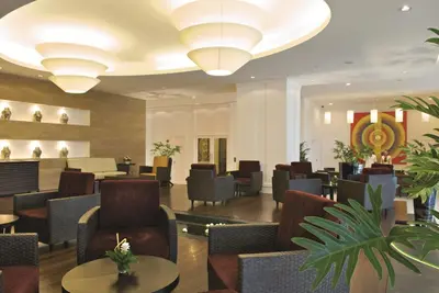 a lobby of a hotel with chairs and tables at The Narathiwas Hotel & Residence Sathorn Bangkok in Bangkok