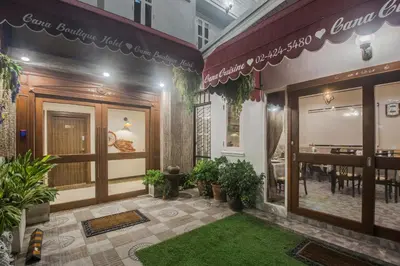 a restaurant with a green lawn in front of a building at Cana Boutique Hotel in Bangkok