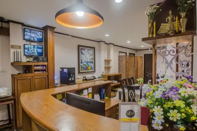 a waiting room with a reception desk and flowers at Cana Boutique Hotel in Bangkok