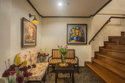 a living room with a couch and a table with flowers at Cana Boutique Hotel in Bangkok