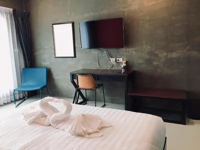 a bedroom with a bed and a desk and a television at Thanks​Pama​ in Bang Khen