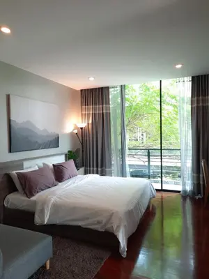 a bedroom with a large bed and a large window at PomPom Home in Bangkok
