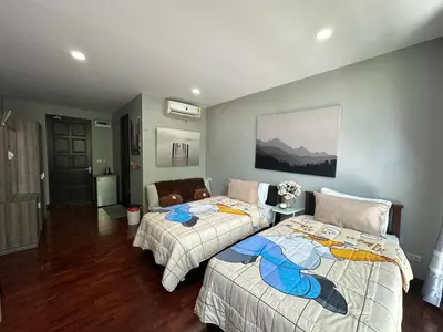 a bedroom with two beds and a couch at PomPom Home in Bangkok
