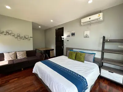 a bedroom with a large bed and a couch at PomPom Home in Bangkok