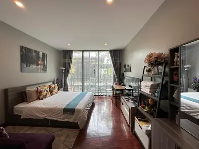 a bedroom with a bed and a large window at PomPom Home in Bangkok
