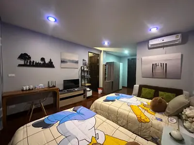 a living room with two beds and a desk at PomPom Home in Bangkok