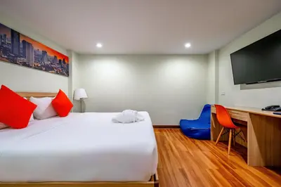 a bedroom with a bed and a desk and a television at 7 Days Premium Hotel at Icon Siam Station - No Parking in Bangkok