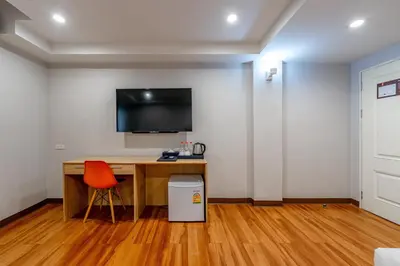 a room with a desk and a television on a wall at 7 Days Premium Hotel at Icon Siam Station - No Parking in Bangkok