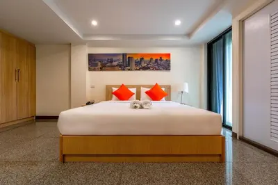 a bedroom with a large white bed with red pillows at 7 Days Premium Hotel at Icon Siam Station - No Parking in Bangkok
