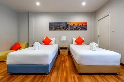 two beds in a room with wood floors at 7 Days Premium Hotel at Icon Siam Station - No Parking in Bangkok