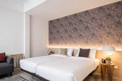 a bedroom with a large white bed and a wall mural at China Cozy Asoke in Bangkok